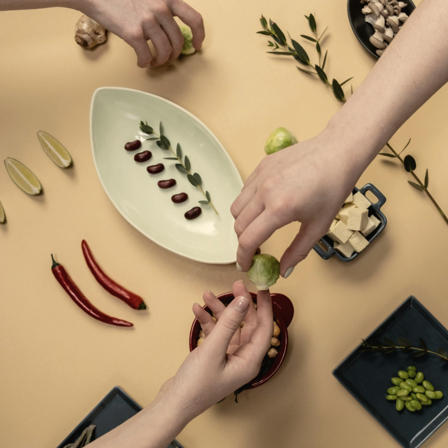 Hands arranging ingredients on a warm beige surface